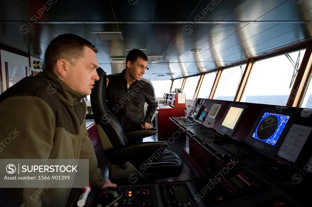 On the bridge of the MV Flintercape a Russian first-officer and a Dutch Cadet study the onboard instruments, during their voyage from Rotterdam, Nethe...