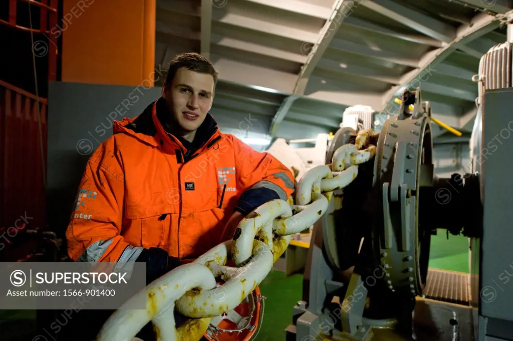 Baltic Sea near Sweden. The Dutch Cadet at container-vessel MV Flintercape, on the prow or front of the ship. He leans against the chains, connected t...