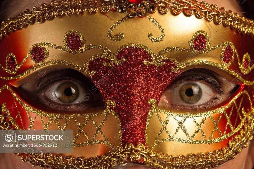 Wide opened eyes of a woman behind a venetian mask