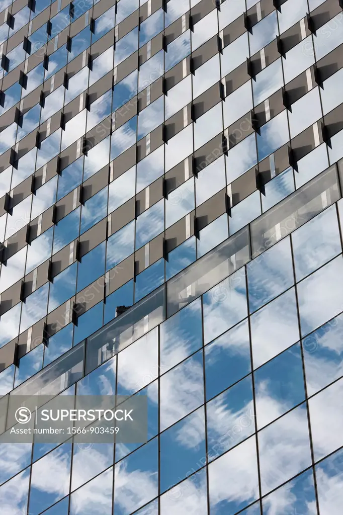 The sky and clouds reflected in the windows of building facades in New York City, USA