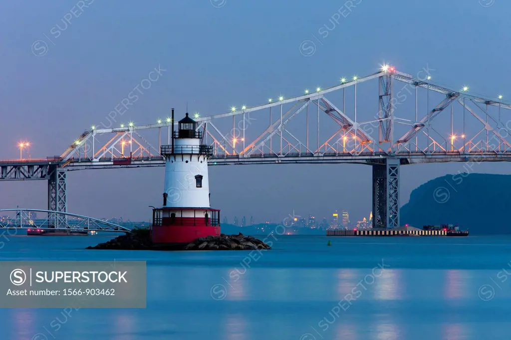 Twilight view of the Tarrytown Lighthouse and Tappan Zee Bridge on the Hudson River near the village of Sleepy Hollow, New York, with the skyline of M...