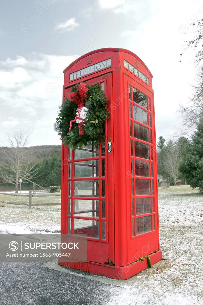 An old-fashioned British telephone booth decorated with a Christmas wreath, in the small town of Rowe, Massachusetts, United States