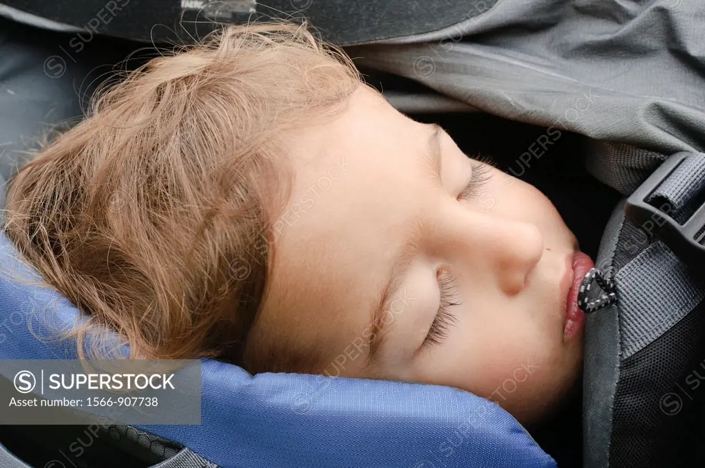 Boy of two asleep in a backpack baby carrier  Photogrpahed in the Austrian Alps