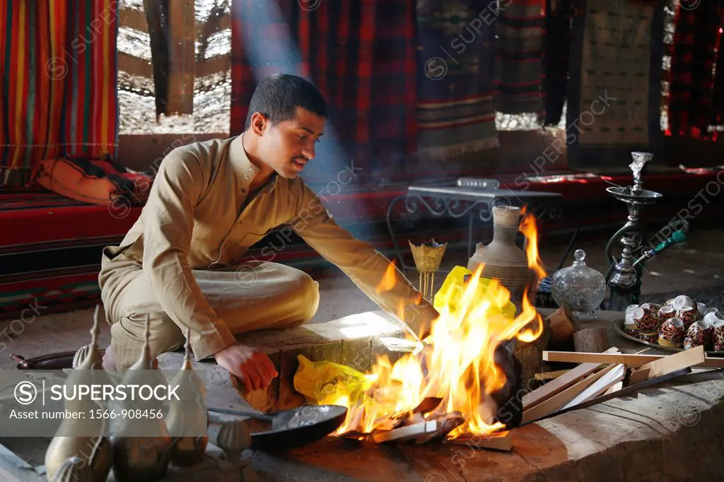 Man setting fire to make tea at a bedouin tent next to Qasr Kharana, Jordan