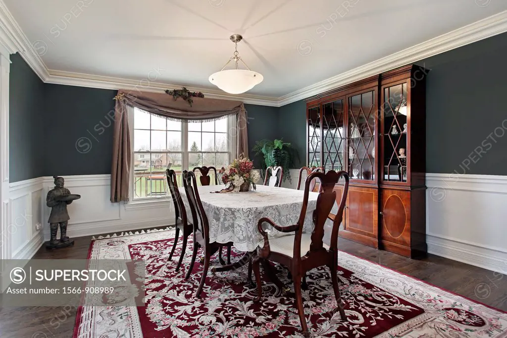 Dining room in luxury home with dark teal walls