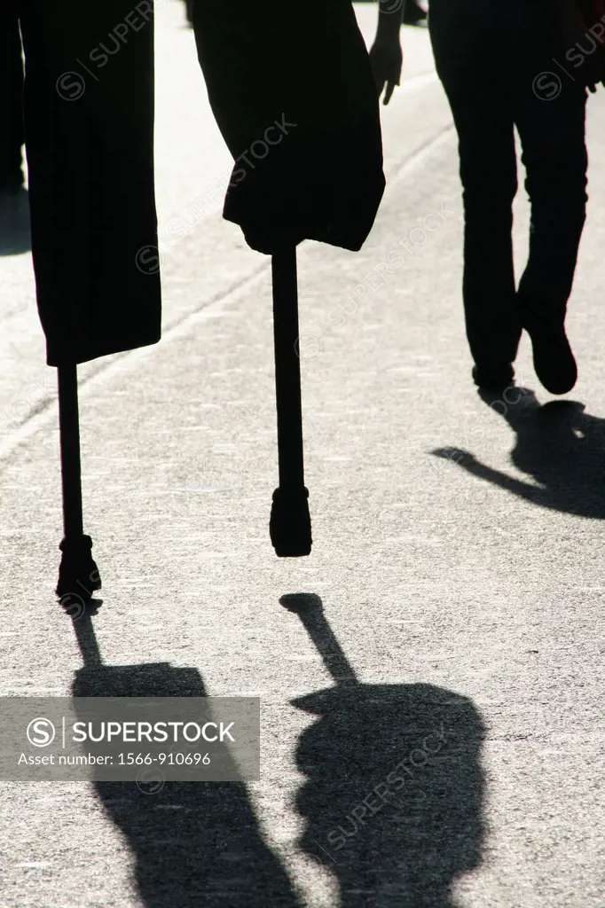 person man walking on stilts in street road in city town