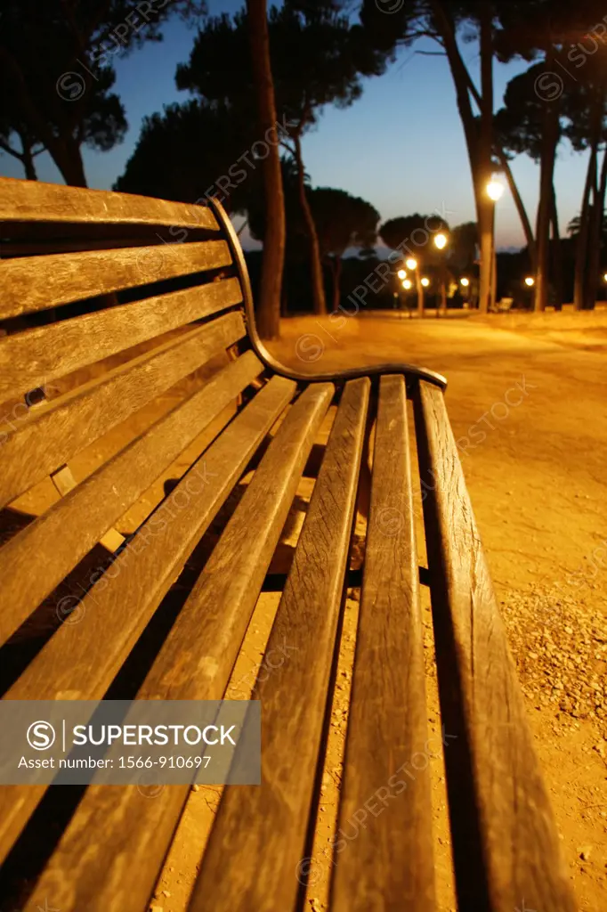 empty bench in villa pamphili park in rome at night