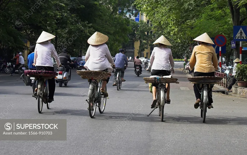 Four women in conical hats on bicycles Hanoi Vietnam