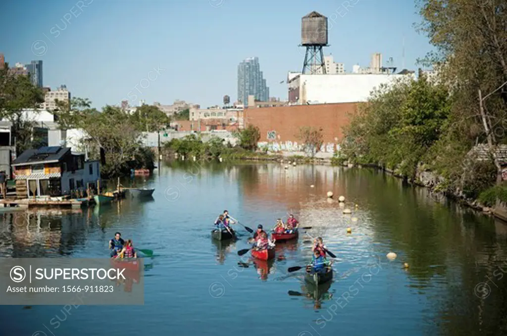 Canoers paddle the polluted inland waterway, the Gowanus Canal  in Brooklyn in New York
