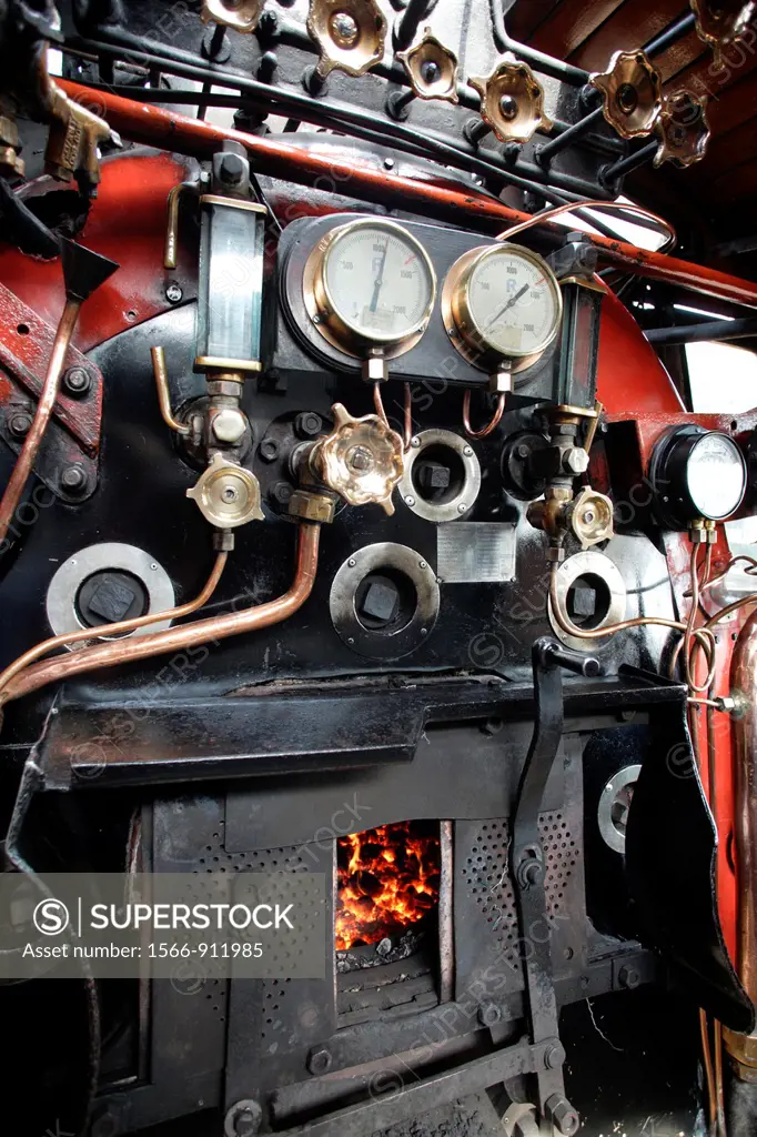 Operator´s stand of an old steam engine of Rovos Rail with its pressure gauges, instruments and copper pipes, coal fire in the fire place, Pretoria, S...