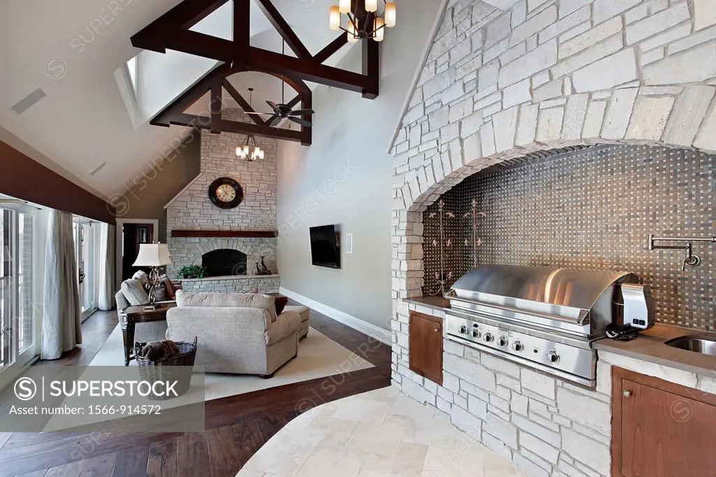 Family room with ceiling wood beams and grill