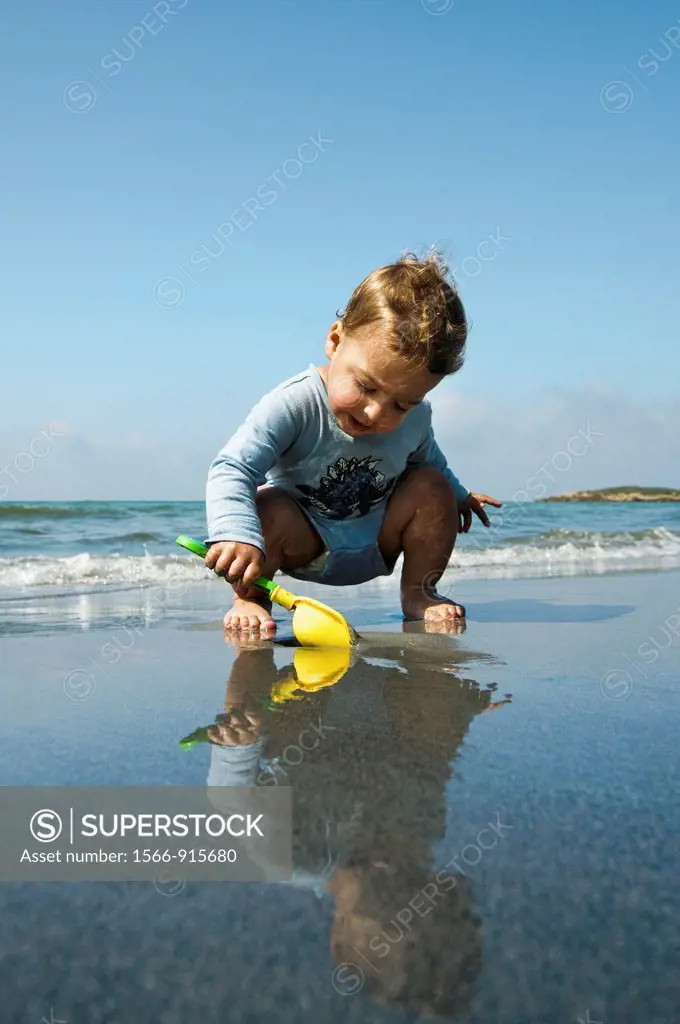 Two year baby boy plays on the beach