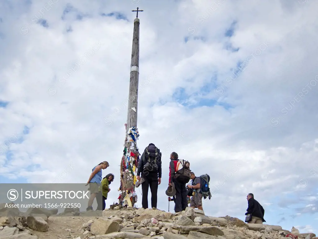 Pilgrims leaving stones at the base of Cruz de Ferro near the village of Foncebadon along the Camino de Santiago