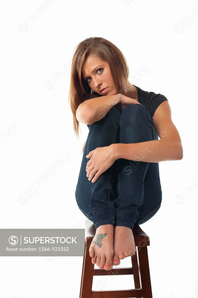 Portrait of young sexy woman sitting on a stool