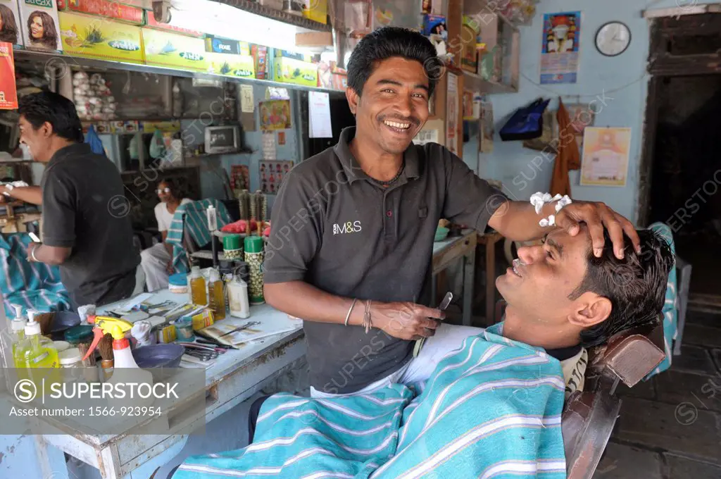 Asia,India,Delhi,indian barber giving man a wetshave