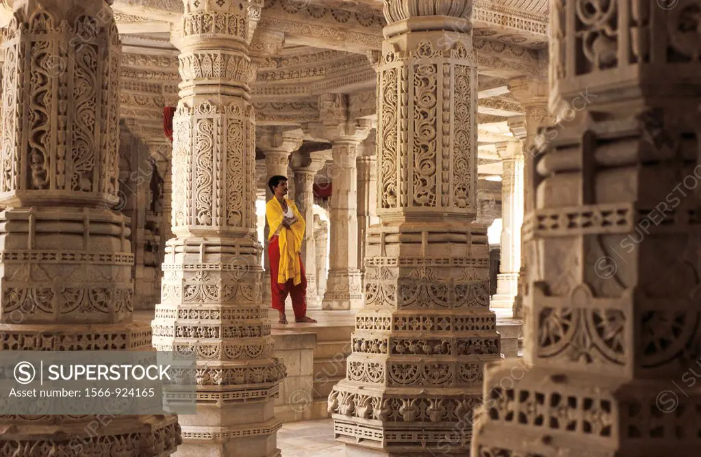 A priest is standing inside the Ranakpur temple in India