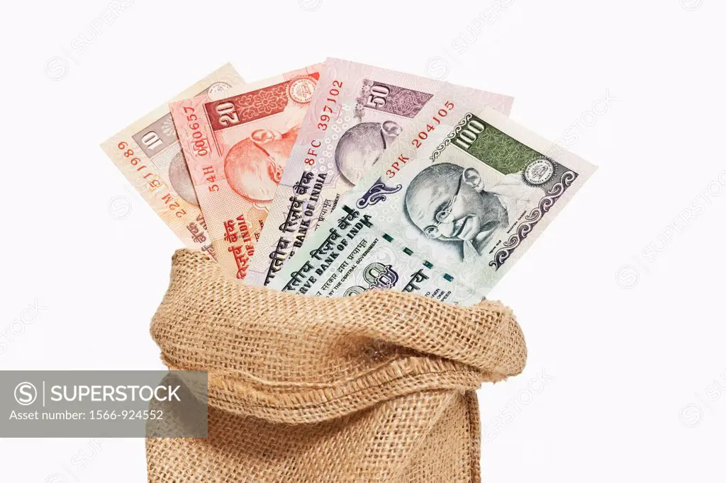 Many diverse Indian rupee bills with the portrait of Mahatma Gandhi are in a jute bag