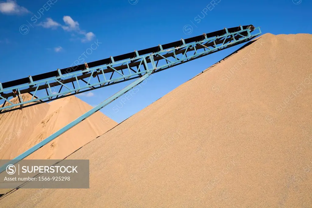 Stacking conveyor and mounds of sand in a commercial sandpit, Quebec, Canada