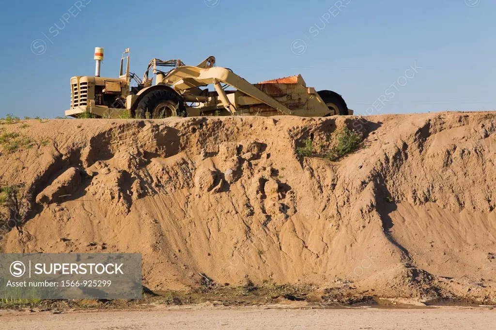 Loader on top of a mound of sand in a commercial sandpit, Quebec, Canada