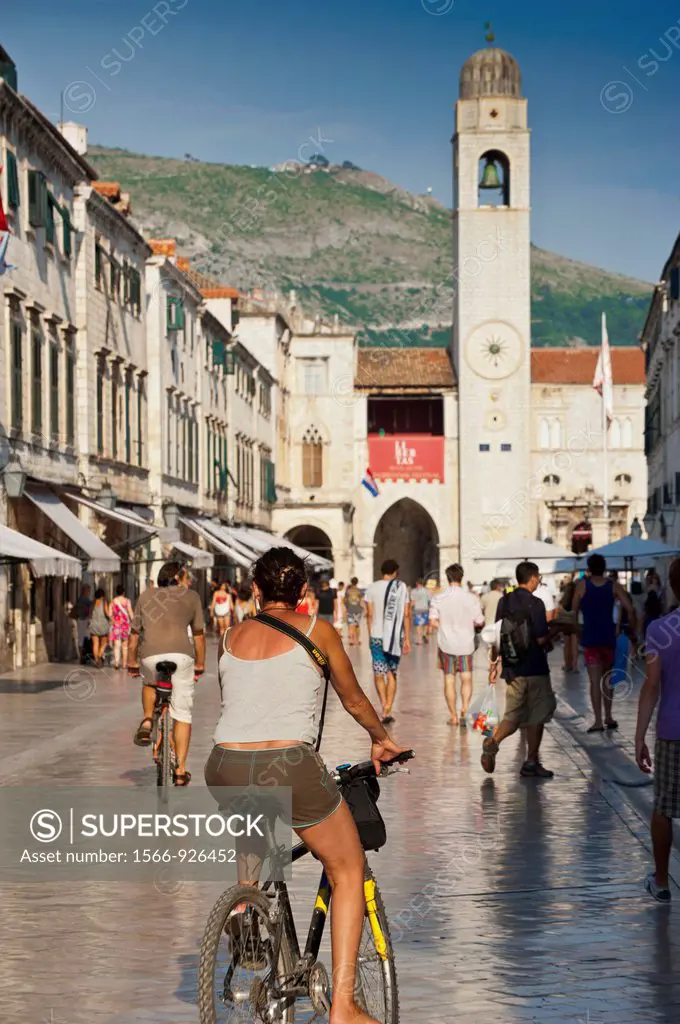 Cyclist in Main street Stadrun and Bell Tower in background  Old Town, Dubrovnik  Croatia