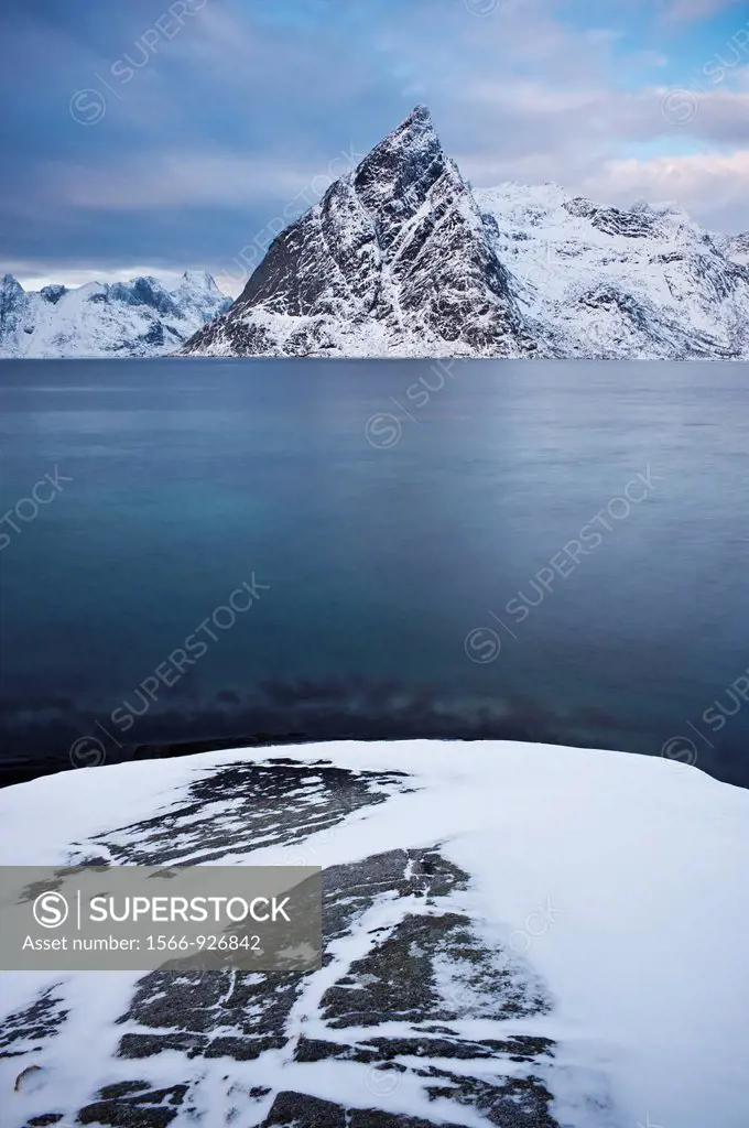 Olstind mountain peak rises from fjord, Lofoten Islands, Norway