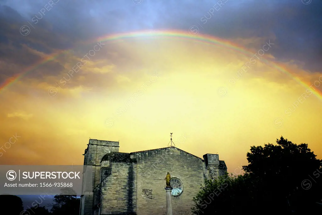 After a rainstorm a rainbow appears over the 13th century Church of St. Saturnin on the outskirts of Pezenas, France