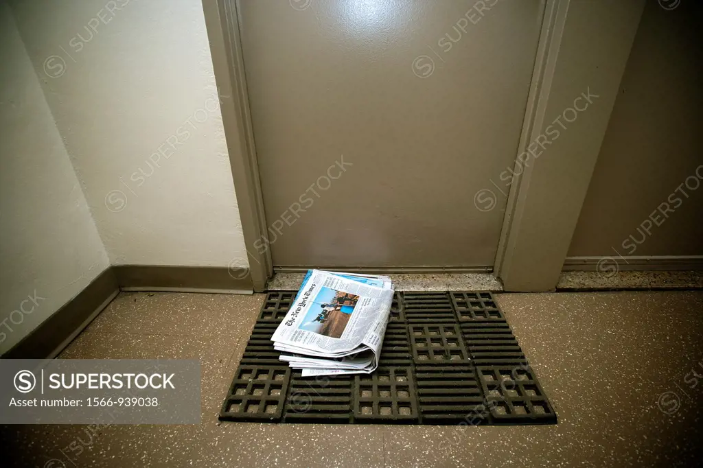 A home delivery copy of the New York Times, containing some of the Sunday sections, is seen in front of a door in an apartment building in New York on...