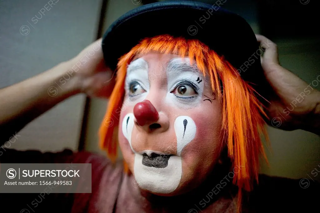 A clown puts on his bowler hat hat as he makes up in his hotel room before attending the 16th International Clown Convention: The Laughter Fair organi...