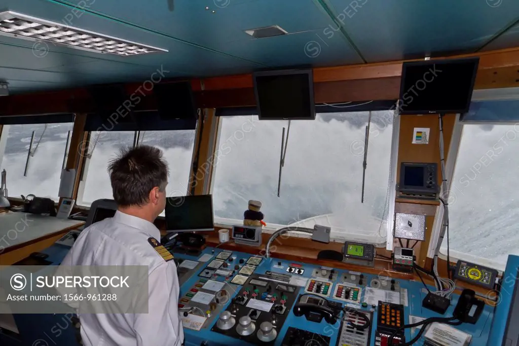 Captain Oliver Kruess on the bridge of the Lindblad Expeditions ship National Geographic Explorer in a Beaufort Scale 10 storm 35 foot seas and 50+ kn...