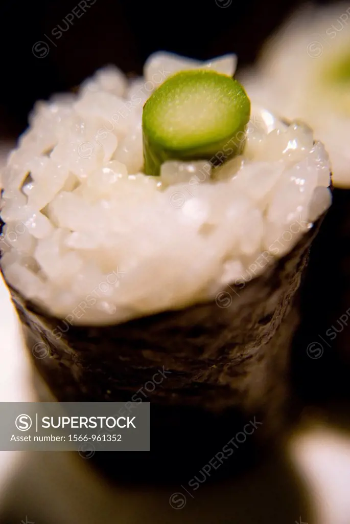 Close up of a sushi maki made of rice and asparagus.