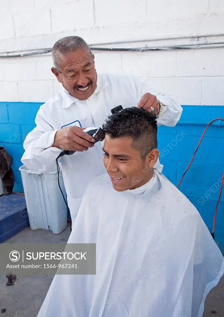 Nogales, Sonora, Mexico - Barber Adan Magdariaga cuts hair at Transportes Fronterizos, a bus station by the US-Mexico border crossing where migrants w...