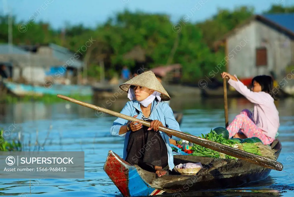 Vietnamese woman selling vegetables from boat Lake Tonle Sap near Siem Reap Cambodia