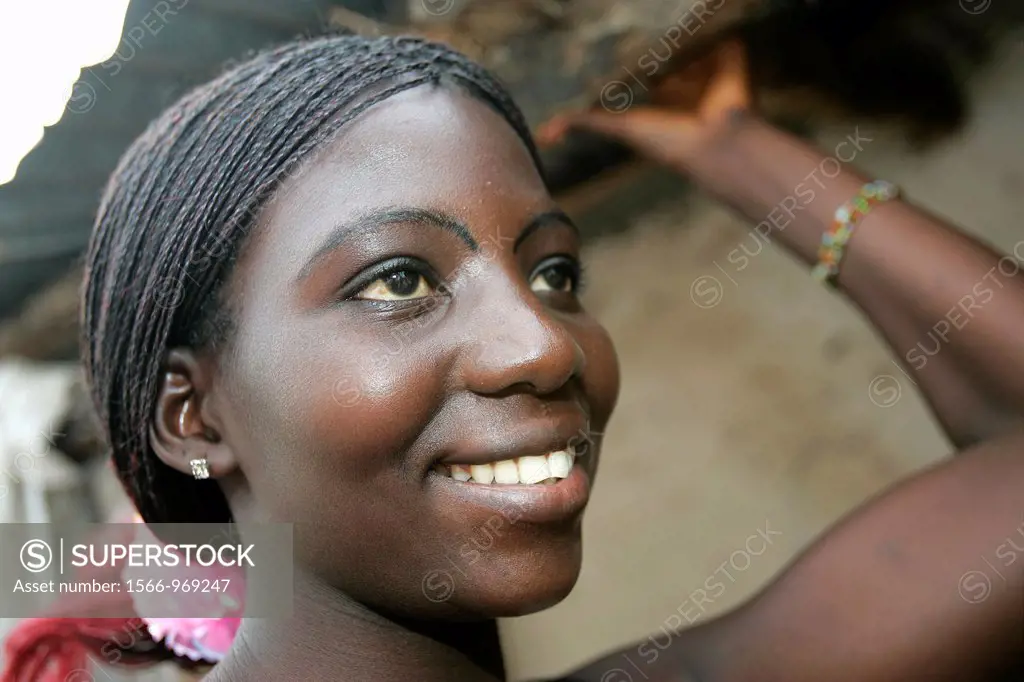 Attractive young Fula woman with braided hair tied back Saravati village The Gambia