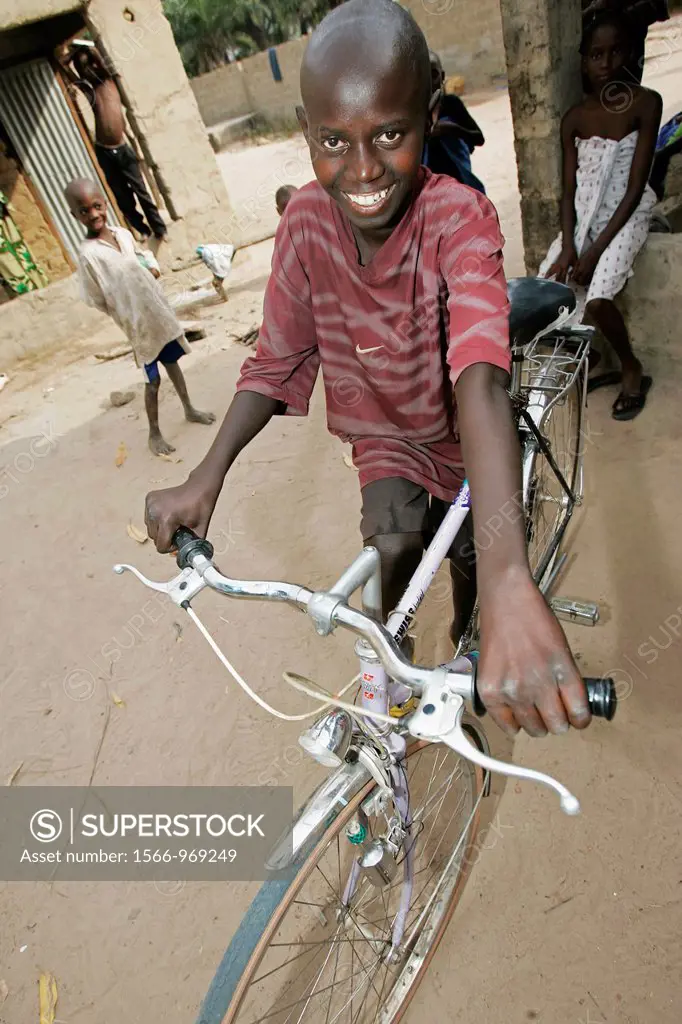 Young Fula boy tries out new bicycle The Gambia