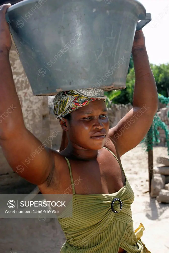 Woman carries large bowl on head Berending village south of The Gambia
