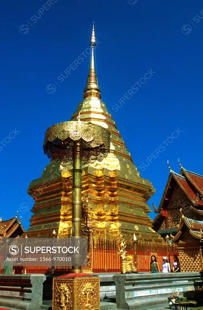 Devotees pray while walking round golden chedi Wat Phrathat Doi Suthep Chiang Mai Thailand