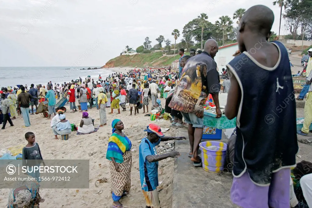 Crowds gather on beach for arrival of fishing boats Bakau The Gambia
