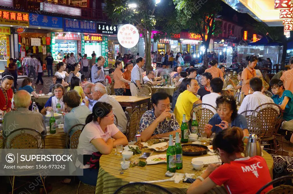 Eating alfresco at outdoor street restaurant at night in Yangshuo China