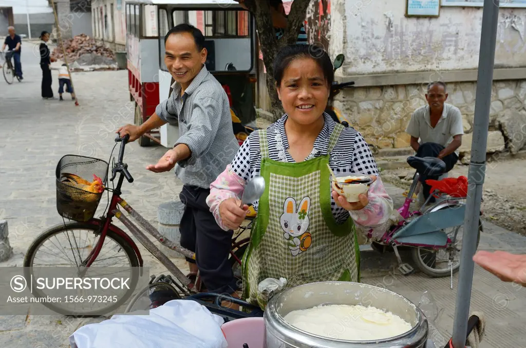 Street vendor selling fresh curd Douhua with syrup offering treat in Fuli China
