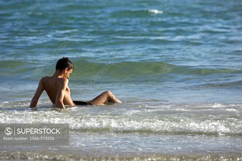 Young man relaxing at beach in shallow water Ko Chang Thailand