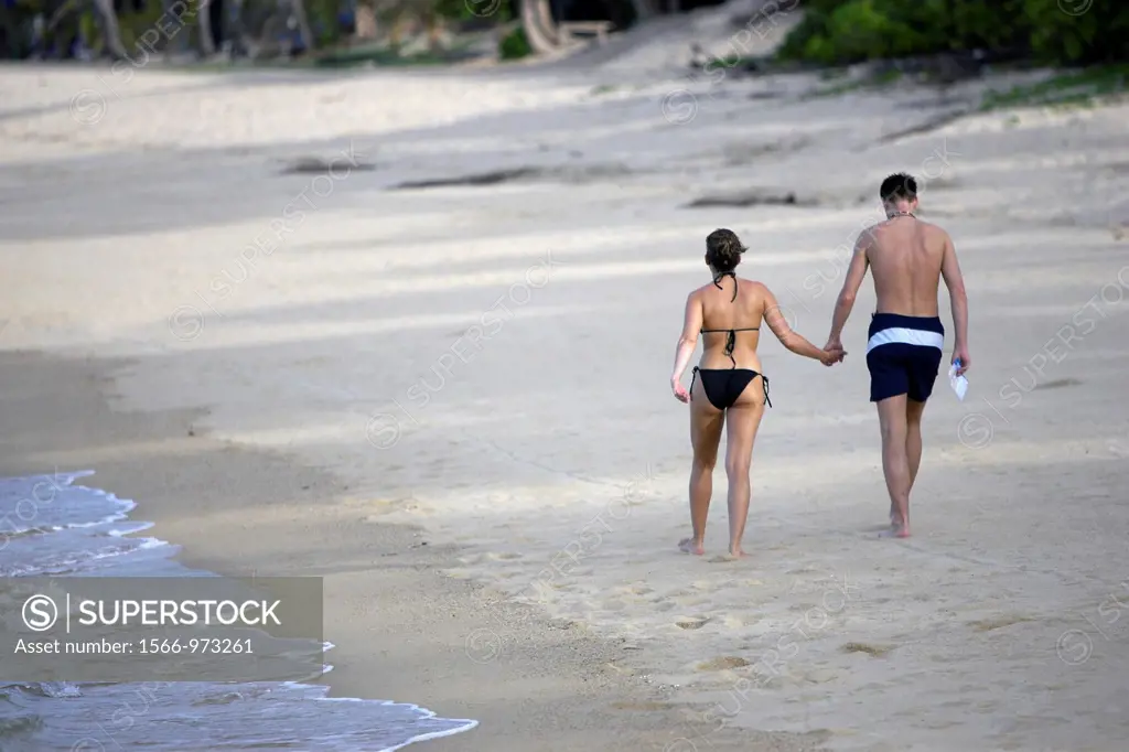 Couple walk hand in hand on deserted Mae Nam beach Ko Samui island Thailand
