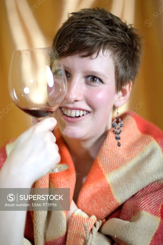 Tilburg, Netherlands. Young woman with plaid and glass of wine.