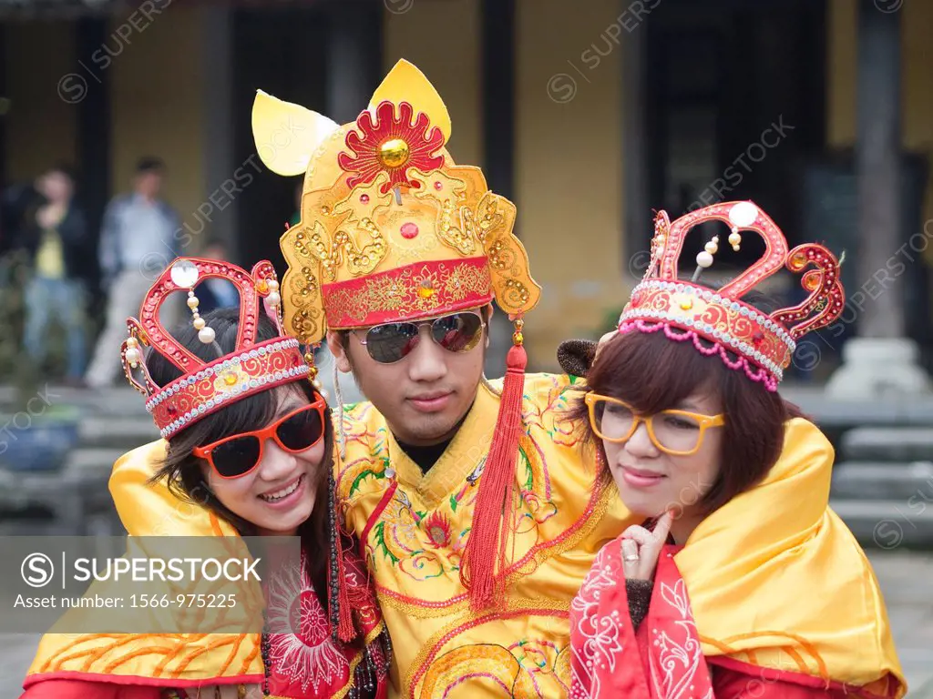 Vietnamese college students pose and play in traditional costime outside museum in Imperial Palace in Hue, Vietnam