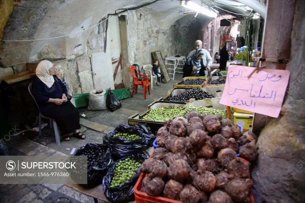 A woman selling olives and more at a market in the old city section of Jerusalem