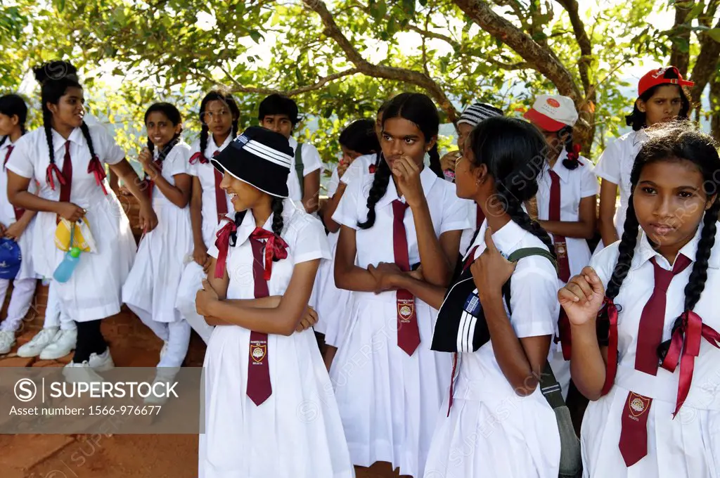 School girls at Sigiriya Lion´s rock, a large stone and ancient rock fortress and palace ruin surrounded by the remains of an extensive network of gar...