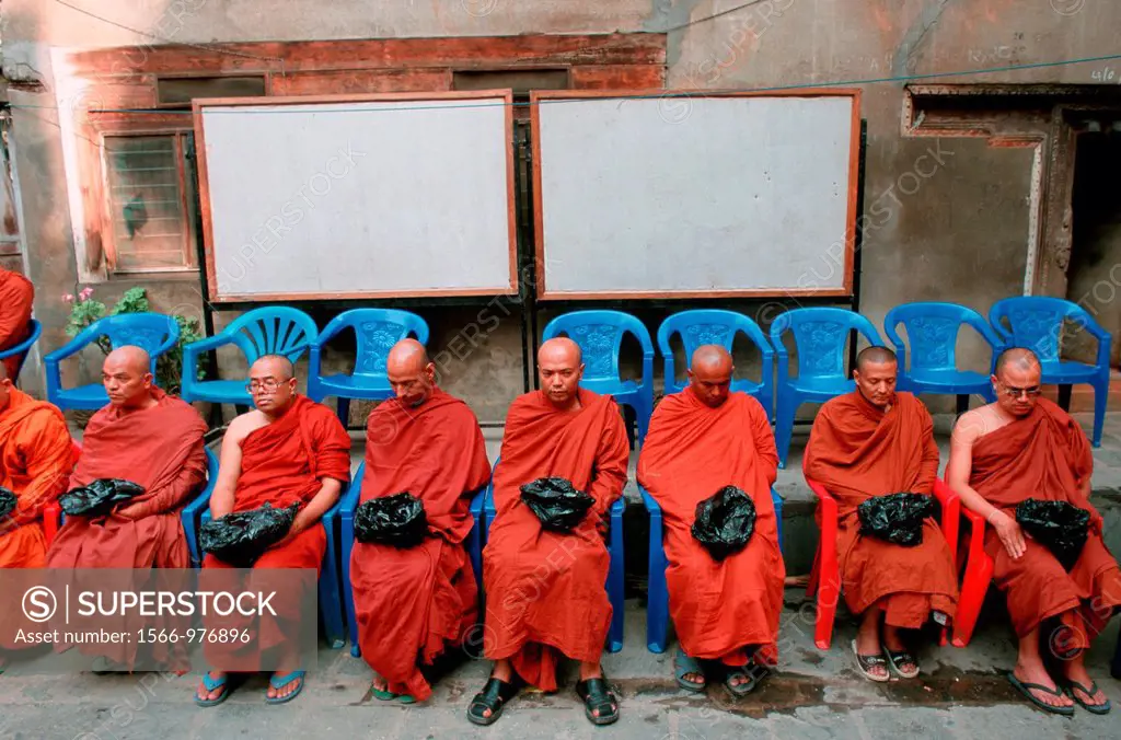 Buddhist monks waiting for alms at Patan, Nepal. They belong to the Theravada sect. Buddhism is very popular in Nepal but almost all of the buddhists ...