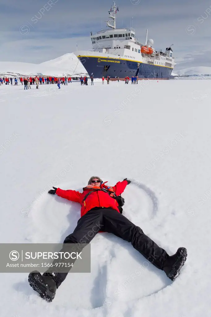 Guest from the Lindblad Expedition ship National Geographic Explorer enjoy making snow angels on sea ice in Antarctica
