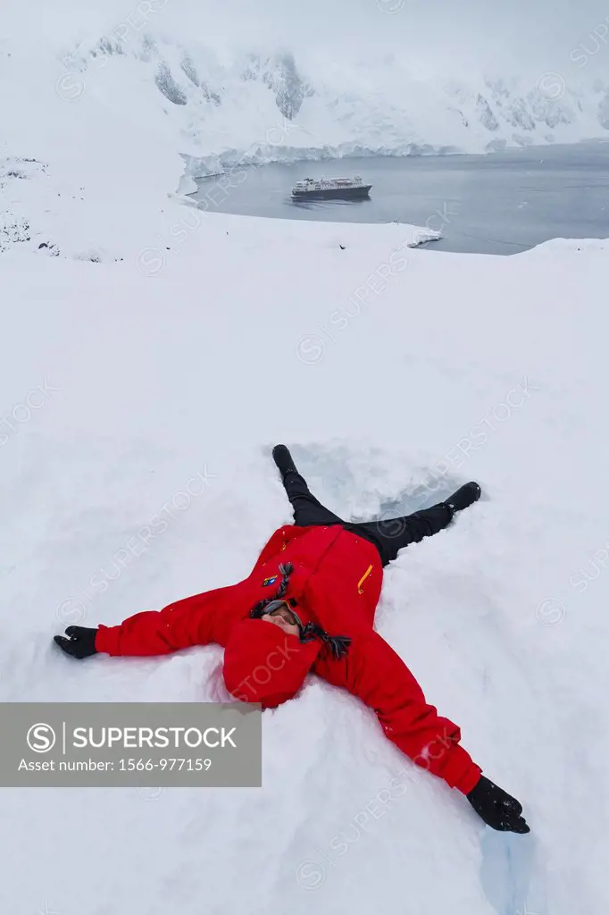 Guests from the Lindblad Expedition ship National Geographic Explorer enjoy making snow angels in fresh snow on Booth Island, Antarctica