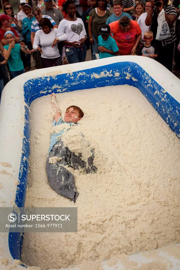 A competitor rolls around in a pool of instant grits during the grits roll competition at the World Grits Festival April 14, 2012 in St  George, SC  T...