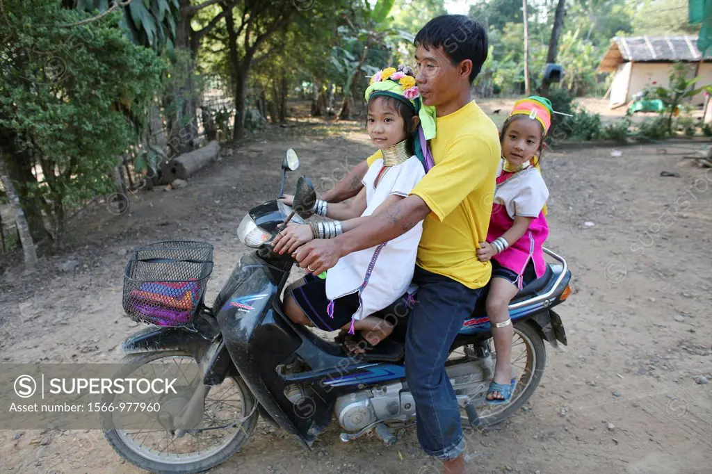 A father rides his moped with his two daughters in the Longneck village Approximately 300 Burmese refugees in Thailand are members of the indigenous g...